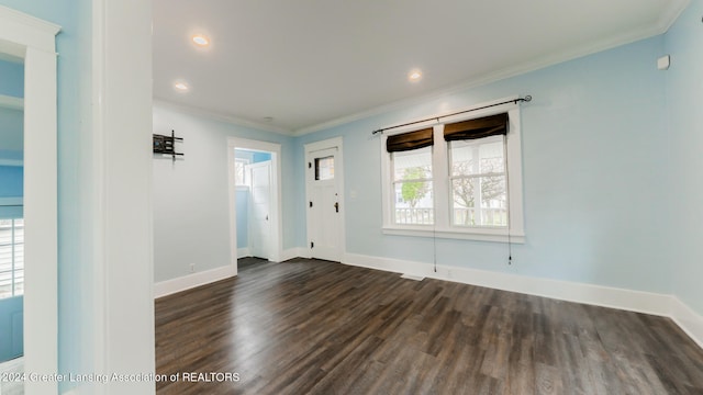 empty room with dark hardwood / wood-style floors and crown molding