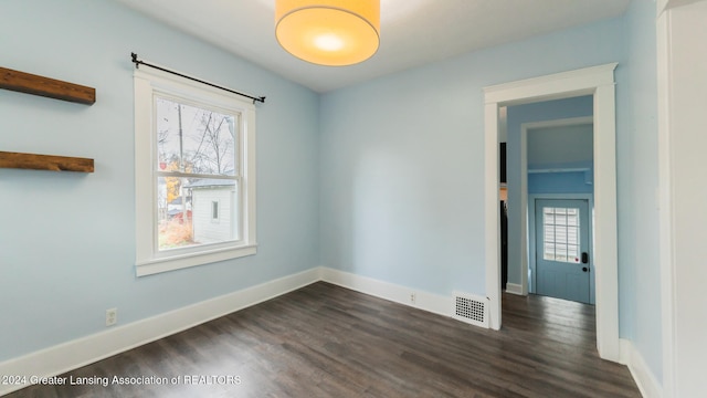 empty room with plenty of natural light and dark hardwood / wood-style floors