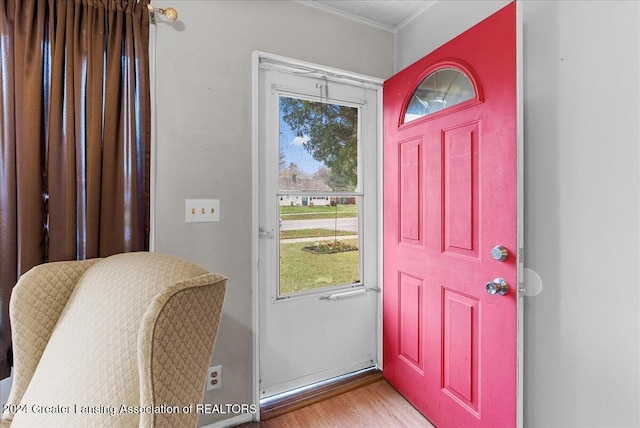 entrance foyer featuring hardwood / wood-style flooring and crown molding