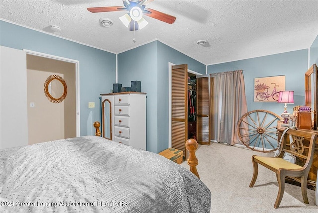 carpeted bedroom featuring ceiling fan, a textured ceiling, and a closet