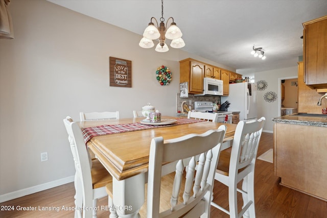 dining room with a chandelier, hardwood / wood-style flooring, and sink