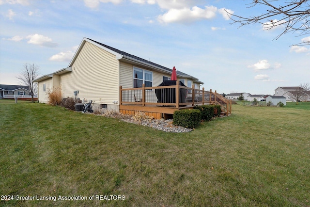 back of house featuring a lawn and a wooden deck