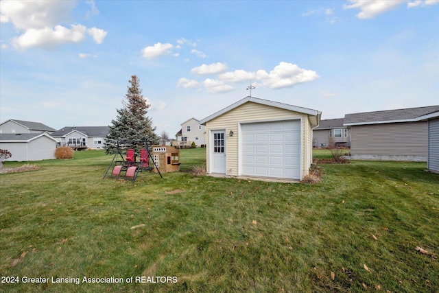 view of yard featuring a garage and an outbuilding