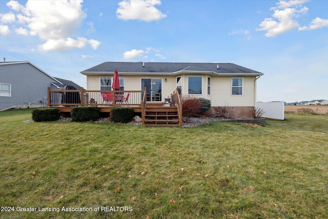 back of property featuring a lawn and a deck