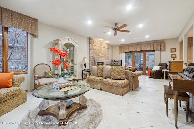 living room featuring ceiling fan, french doors, and a brick fireplace