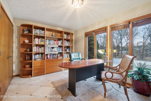 office with plenty of natural light, light tile patterned floors, and a textured ceiling