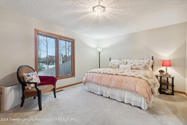 bedroom featuring a textured ceiling and carpet floors