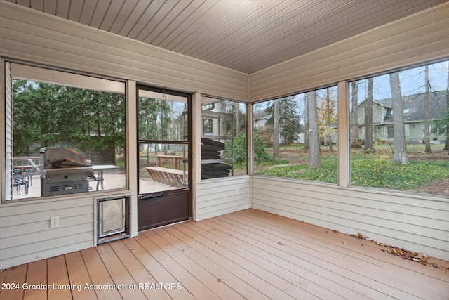 unfurnished sunroom featuring plenty of natural light and wooden ceiling