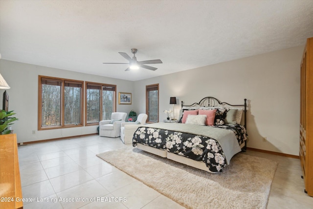 tiled bedroom featuring ceiling fan and a textured ceiling