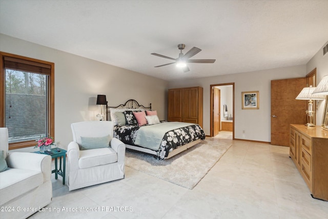 bedroom featuring ensuite bath, ceiling fan, and light tile patterned flooring