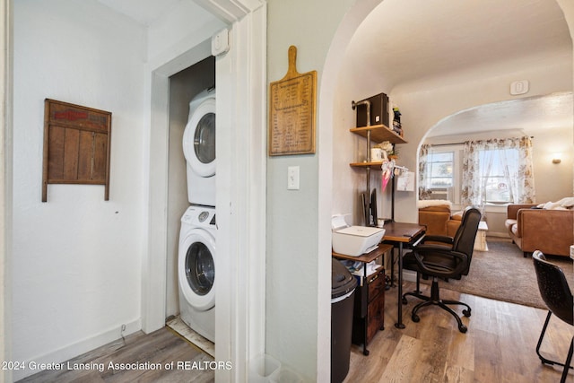 laundry area featuring hardwood / wood-style floors and stacked washer / dryer