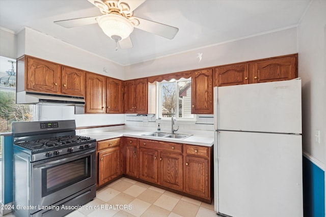 kitchen with ceiling fan, sink, stainless steel range with gas cooktop, backsplash, and white fridge