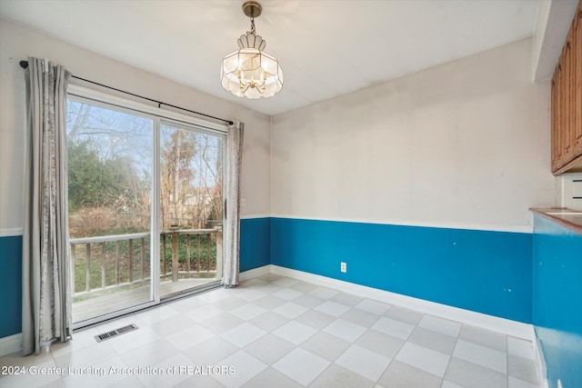 unfurnished dining area featuring an inviting chandelier and a healthy amount of sunlight