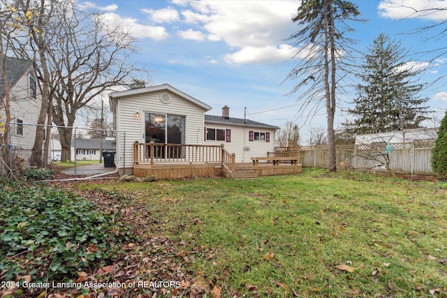 back of house with a deck and a yard