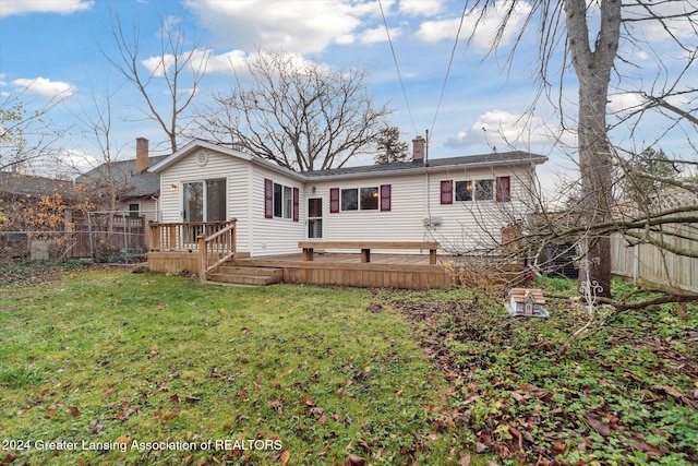 rear view of property featuring a deck and a lawn