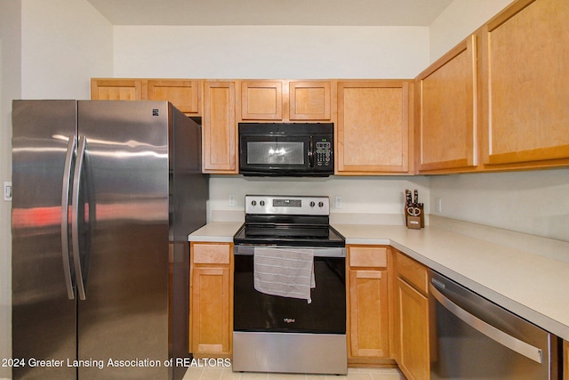 kitchen featuring light brown cabinetry, stainless steel appliances, and light tile patterned flooring