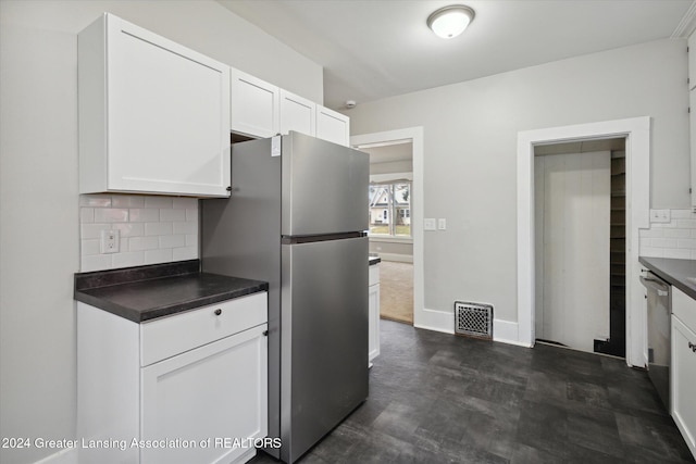 kitchen with tasteful backsplash, white cabinetry, and appliances with stainless steel finishes