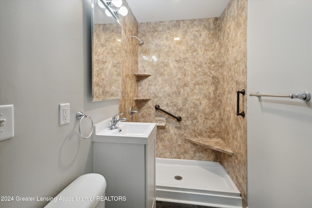 bathroom featuring vanity, toilet, and tiled shower