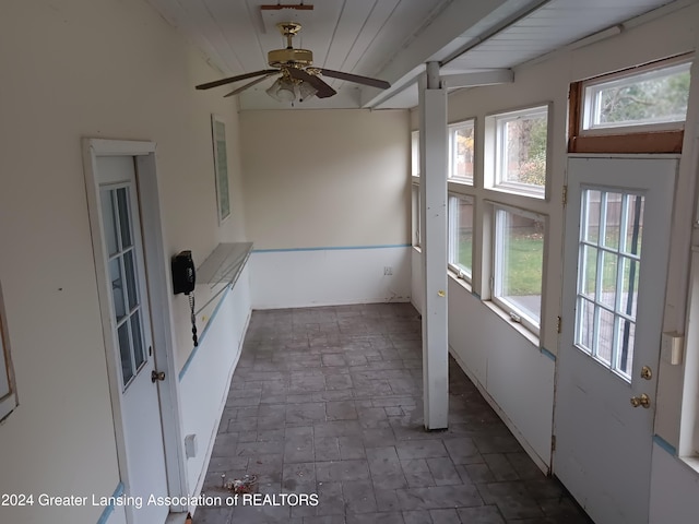 unfurnished sunroom with ceiling fan