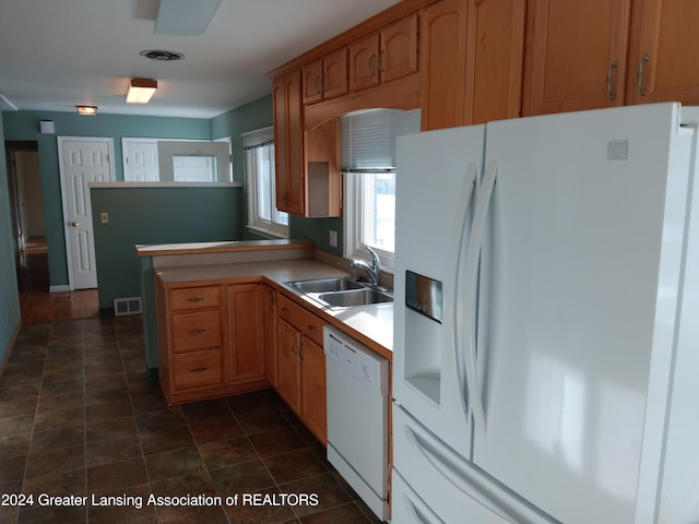 kitchen with kitchen peninsula, white appliances, and sink