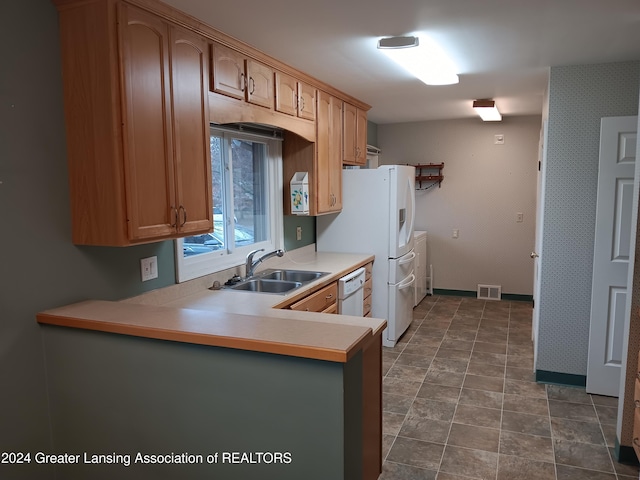 kitchen with kitchen peninsula, white dishwasher, and sink