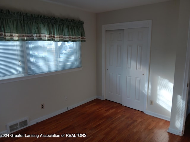 unfurnished bedroom featuring hardwood / wood-style floors and a closet