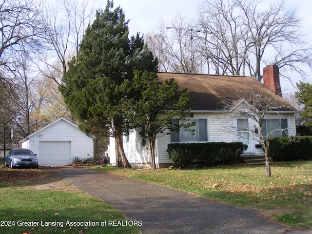 view of front of house featuring an outbuilding, a front lawn, and a garage