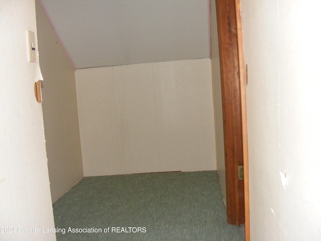 corridor with carpet flooring and vaulted ceiling