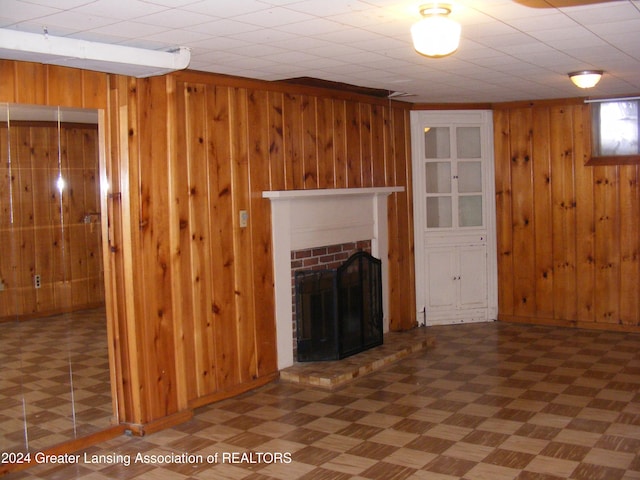 unfurnished living room with wooden walls and a brick fireplace