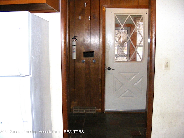 doorway with wood walls