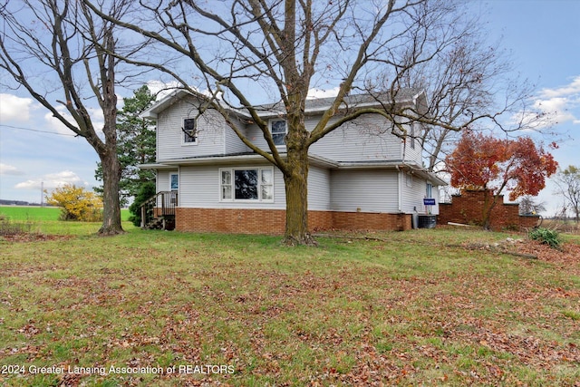 view of home's exterior with a lawn and central AC unit