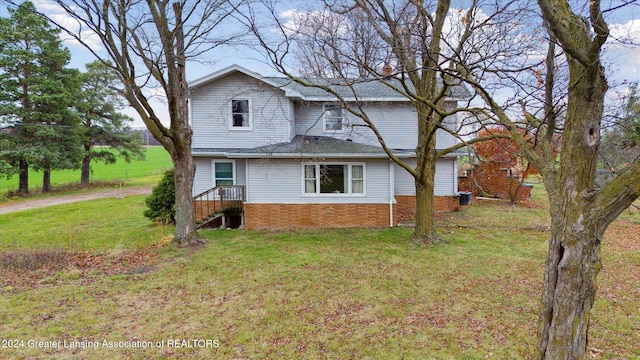 rear view of property featuring a lawn