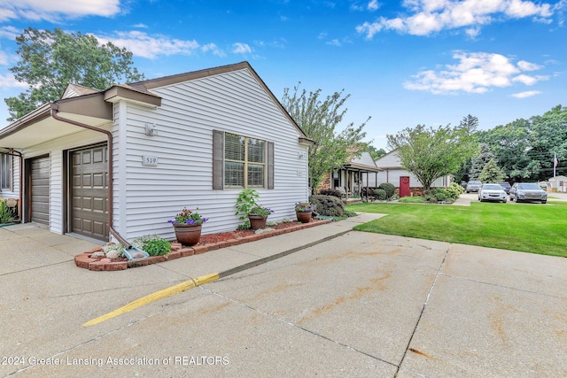 view of side of home featuring a lawn and a garage