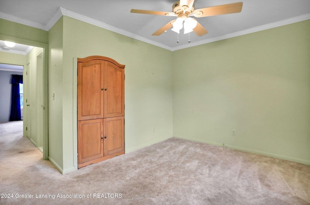 empty room with crown molding, ceiling fan, and light carpet