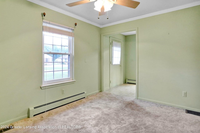 spare room with baseboard heating, light carpet, plenty of natural light, and ornamental molding