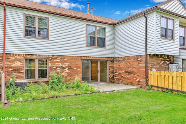 back of property featuring central AC unit, a yard, and a patio