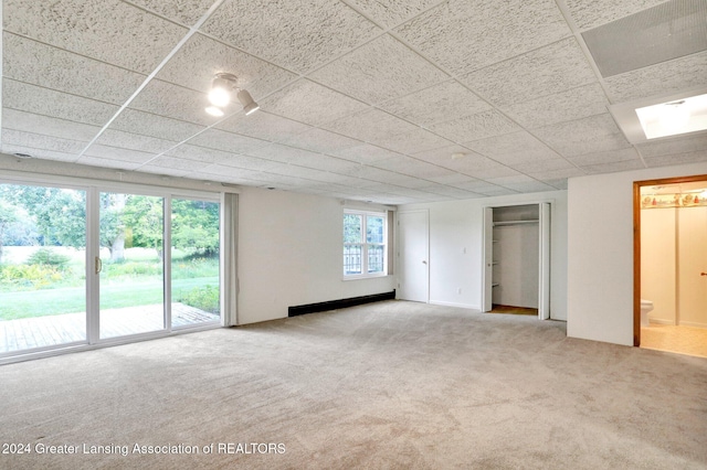 empty room featuring a paneled ceiling and light colored carpet