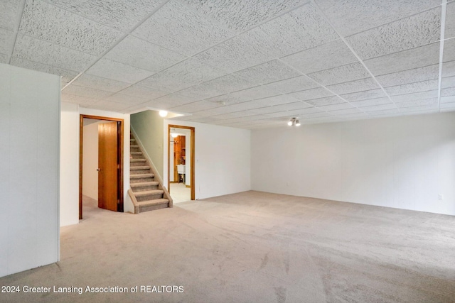 basement with light carpet and a drop ceiling