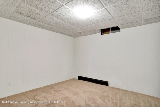 carpeted spare room with a drop ceiling