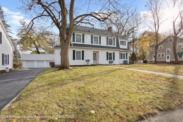 view of front facade with cooling unit, a front lawn, an outdoor structure, and a garage