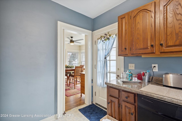 kitchen featuring ceiling fan, light hardwood / wood-style floors, and black dishwasher