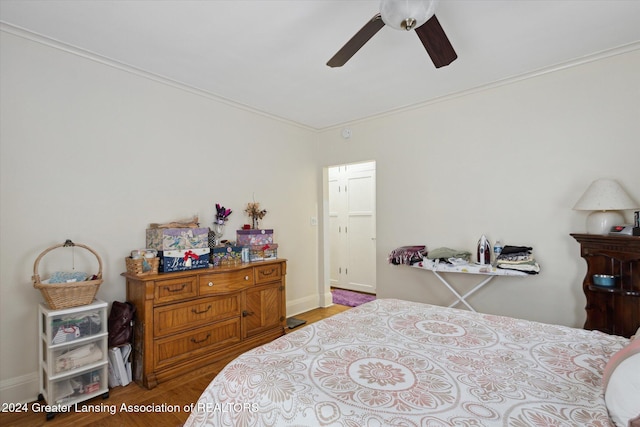 bedroom with ceiling fan, crown molding, and light hardwood / wood-style flooring