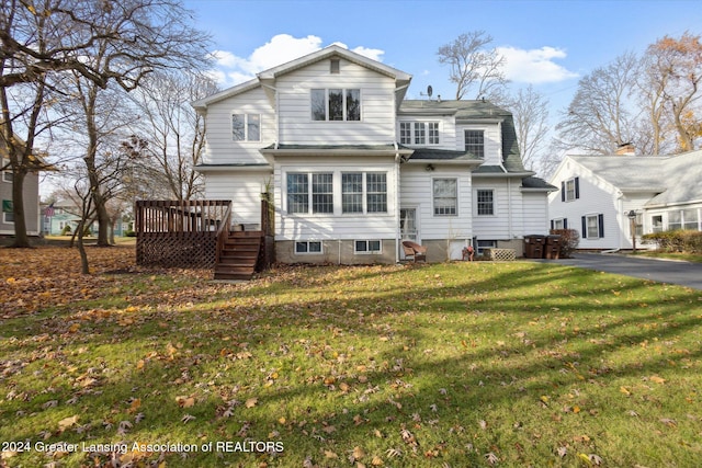 rear view of property featuring a lawn and a deck