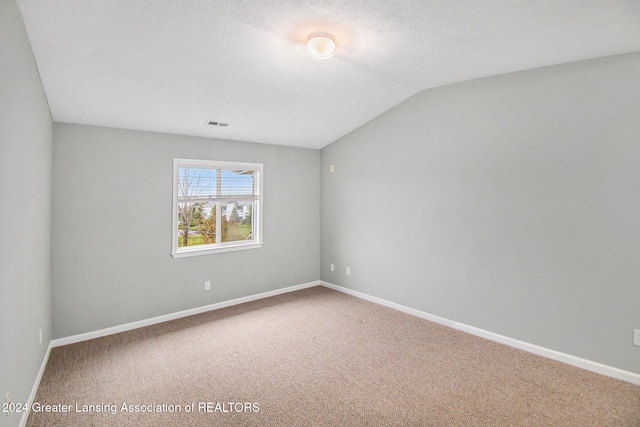 carpeted spare room with lofted ceiling and a textured ceiling