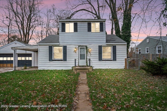 view of front facade with a carport, a garage, and a yard