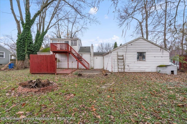 back of property with a wooden deck and an outdoor fire pit