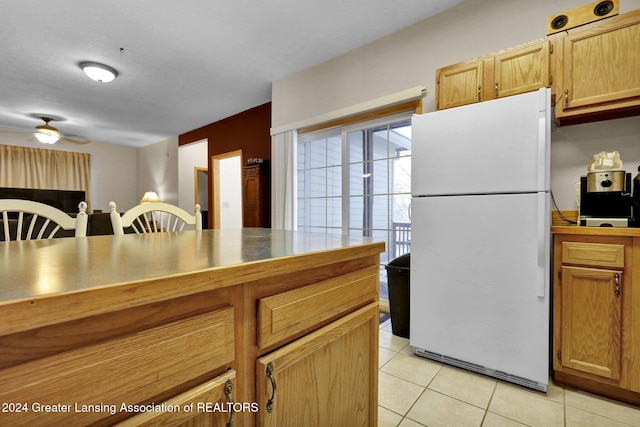 kitchen with light tile patterned floors, white fridge, and ceiling fan