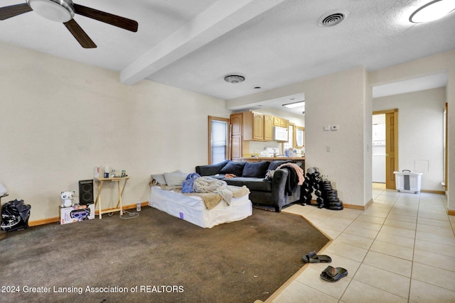 tiled living room with beam ceiling, a textured ceiling, and ceiling fan