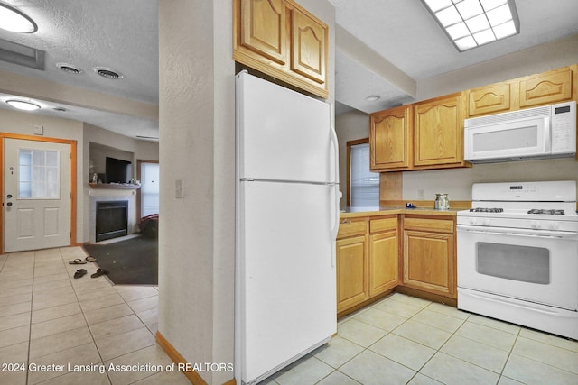 kitchen with white appliances and light tile patterned floors