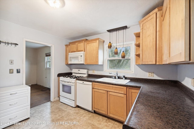 kitchen featuring light brown cabinetry, white appliances, sink, decorative light fixtures, and light hardwood / wood-style floors